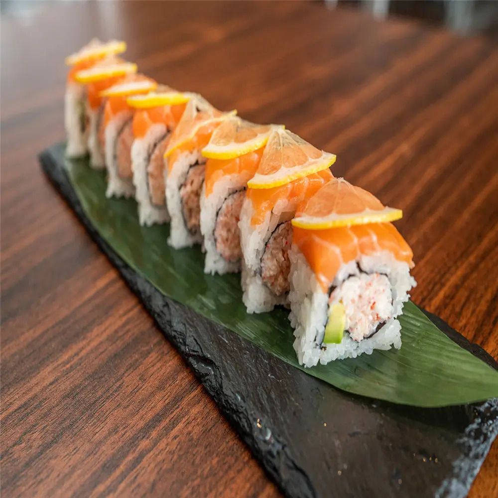Salmon Lemon Sushi features sushi rolls topped with fresh salmon slices and lemon wedges